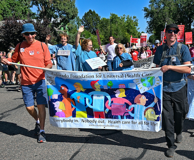 A bunch of frustrated Coloradans march for single payer health care and health care for everyone now at the Colorado Capitol. The slogan is "Stand Up to Corporate Greed!"